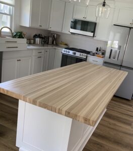 Custom solid White Oak kitchen island top with a natural matte finish in a bright, modern kitchen remodel.