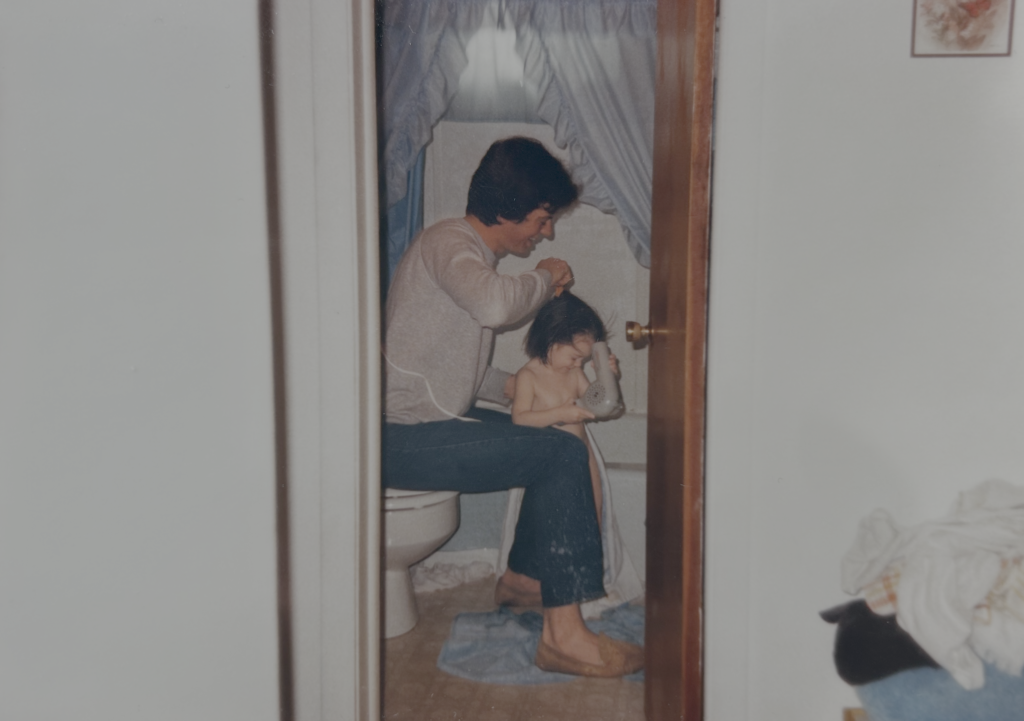 Dad blowdrying a 2year old Shannon, from Mr.Countertops, hair in their old apartment bathroom.