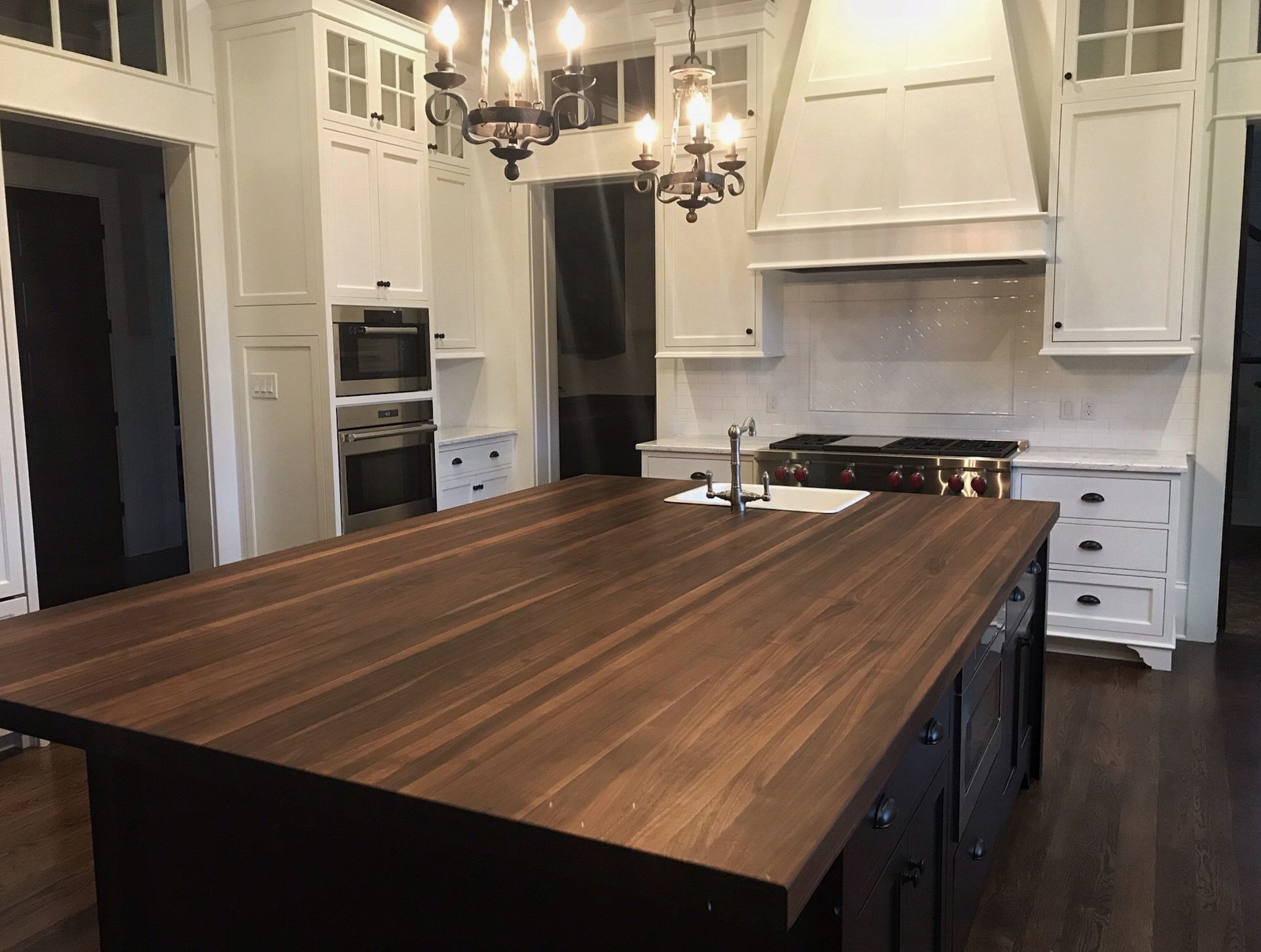 Custom solid walnut kitchen island top with modern seating overhang in a professional kitchen remodel. | Mr.Countertops