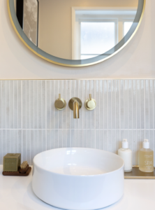 Modern bathroom remodel by Mr.Countertops featuring full-height light slate wall tile and a white porcelain vessel sink sitting on a custom wood vanity.