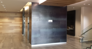 Industrial commercial wall cladding and custom tile installation by Mr.Countertops in a Cleveland Ohio business facility, featuring seamless solid surface panels and gray porcelain tilework for a modern, durable finish
