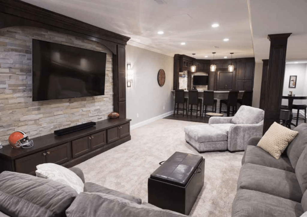 Finished basement remodel with cozy lighting, custom wood bar, and modern entertainment area.