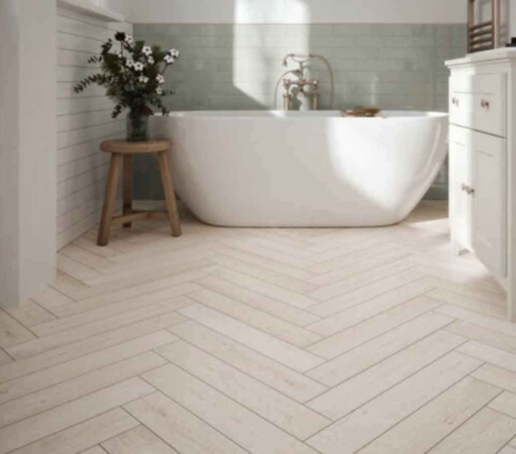 Country-style bathroom floor featuring a custom inverted herringbone V-pattern tile layout in a modern farmhouse aesthetic.