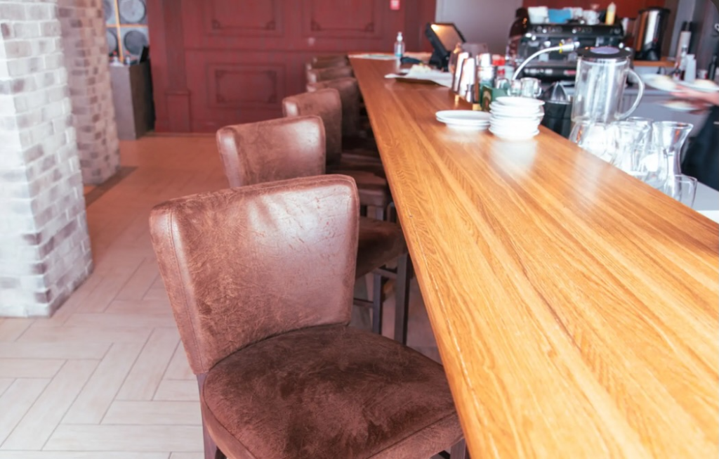 Handcrafted solid oak breakfast bar with a natural oil finish and soft square edges, custom-built for a modern farmhouse kitchen in Northeast Ohio.