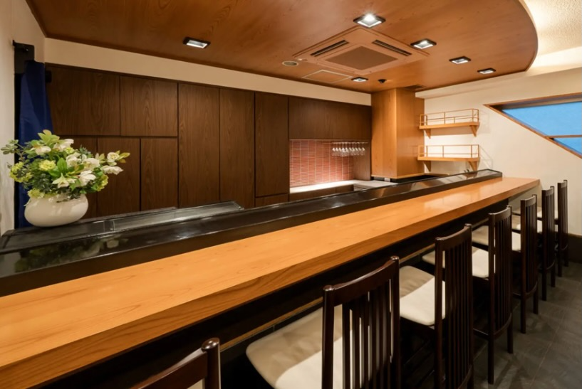 Custom 30-foot solid wood plank breakfast bar with a light tan varnish, installed as a luxury hospitality sit-up counter in a Cleveland, Ohio hotel.