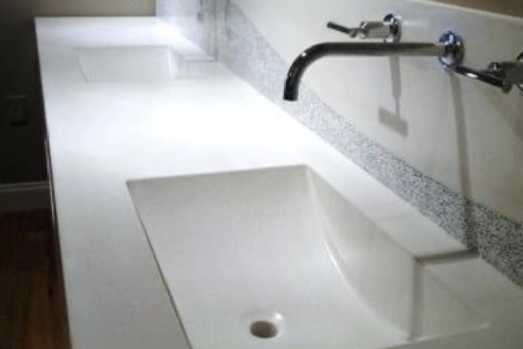 Commercial restroom solid surface trough sink with multiple integrated basins for a Northeast Ohio facility.