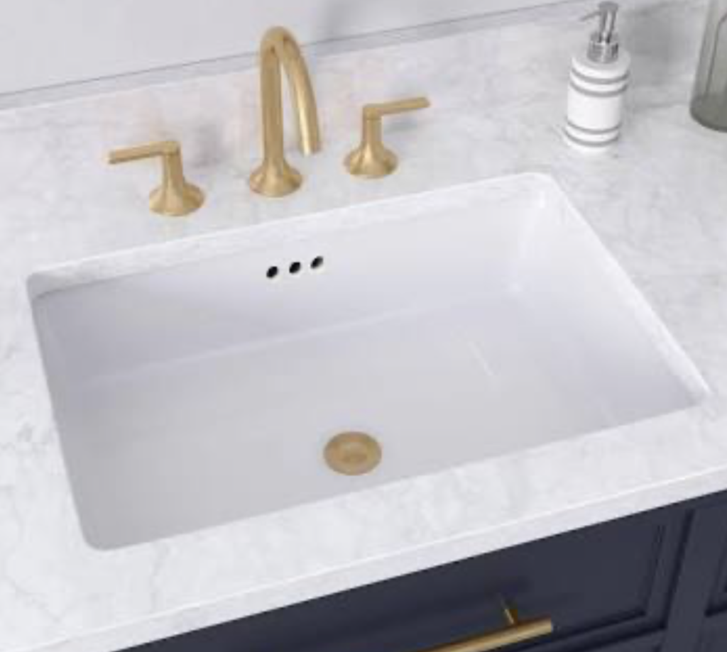White seamless Corian vanity with integrated sink and gold faucet in a luxury Northeast Ohio bathroom renovation.