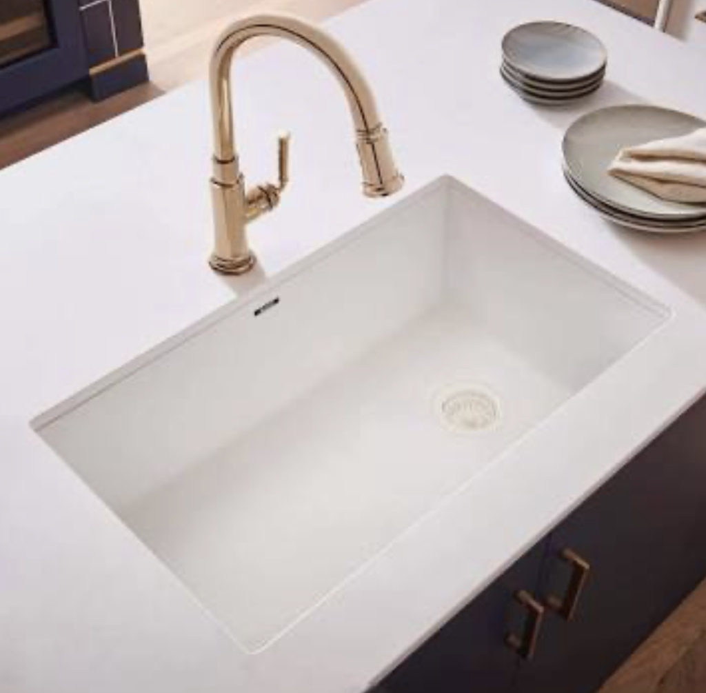 Durable solid surface kitchen sink integrated into a countertop with a coved backsplash in Northeast Ohio.