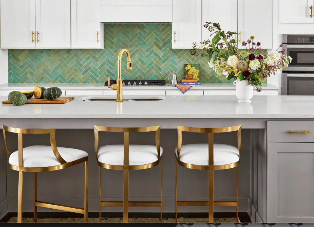 Modern kitchen backsplash featuring emerald green subway tiles installed in a crisp herringbone pattern with contrasting white grout lines.