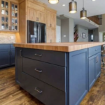 This Cleveland-area kitchen features a handcrafted Acacia wide-plank island paired with custom navy blue cabinetry for a modern, spa-like aesthetic. | Mr.Countertops