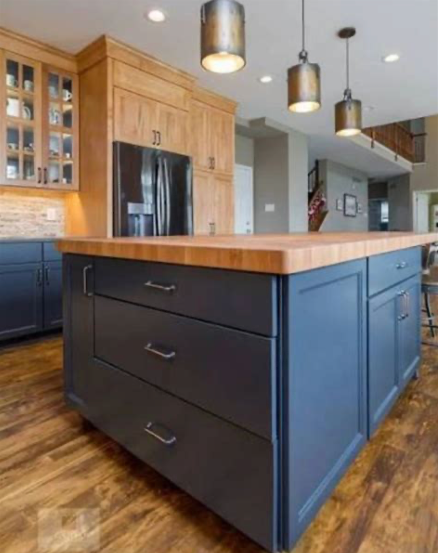 This Cleveland-area kitchen features a handcrafted Acacia wide-plank island paired with custom navy blue cabinetry for a modern, spa-like aesthetic. | Mr.Countertops