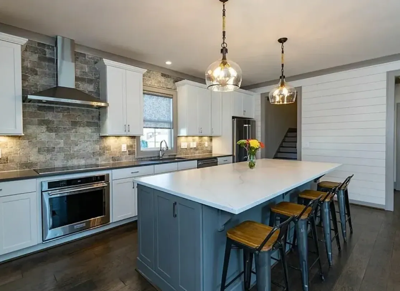 Rustic kitchen featuring stone backsplash and custom solid surface countertops
