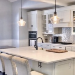 Luxury kitchen remodel featuring a custom solid surface Corian island with modern bar seating and a contemporary black faucet. | Mr.Countertops