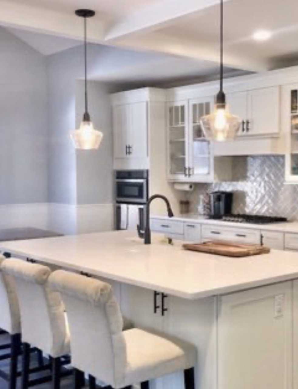 Luxury kitchen remodel featuring a custom solid surface Corian island with modern bar seating and a contemporary black faucet. | Mr.Countertops
