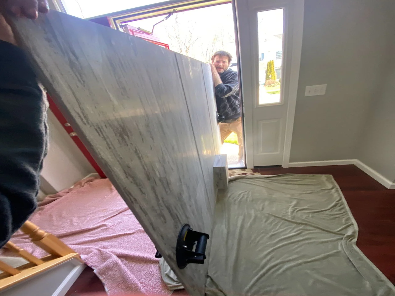 The team at Mr.Countertops, Shannon and David stop at the bottom of the stairs before carrying custom 250 pound shower panel for a bathroom renovation in Copley Ohio.
